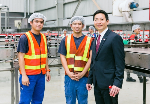 Mr. Pornwut Sarasin, Chairman of Lao Coca-Cola Bottling Co., Ltd. with two plant staff at the first Coca-Cola bottling plant in Lao PDR. (PRNewsFoto/ThaiNamthip Limited)